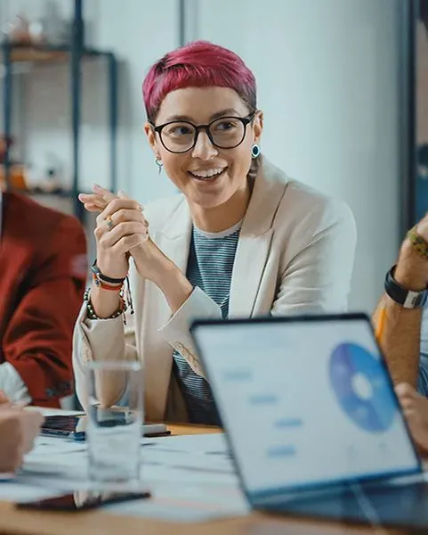 Short-haired woman smiling in a business meeting.